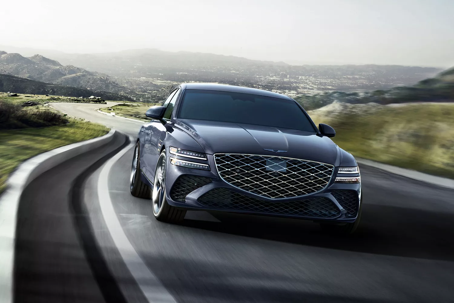 7/8 front passenger view of Genesis G80 in Ceres Blue driving country road with rolling hills